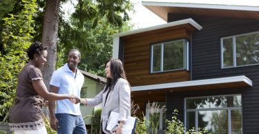 A couple meeting a real estate agent in front of a property because they found her through realtor reviews