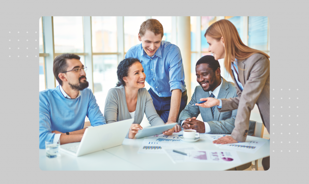 Business colleagues at a table happy about their enterprise SEO efforts.