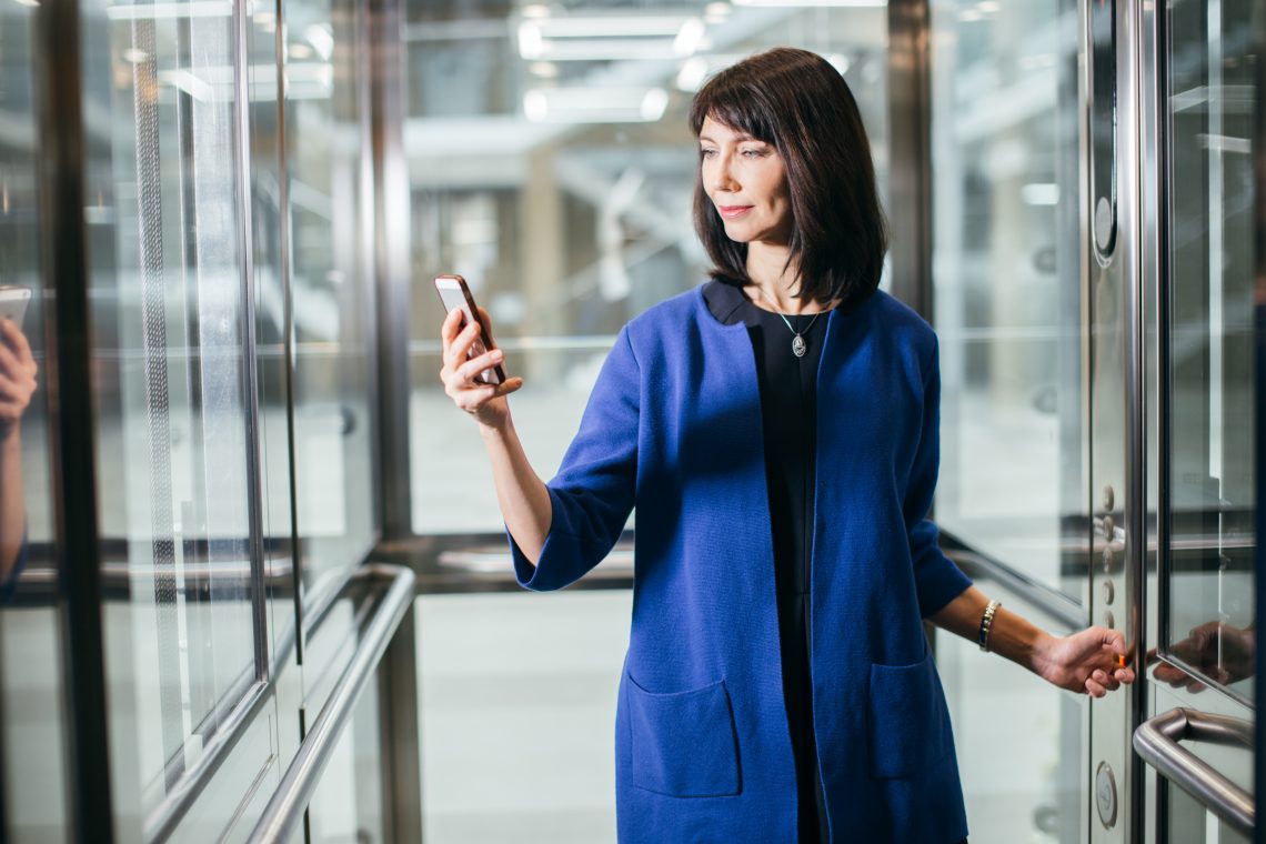 adult businesswomen in suit using smartphone