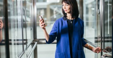 adult businesswomen in suit using smartphone