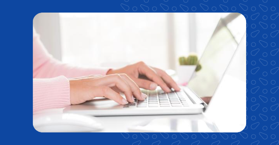 Person typing on their laptop.