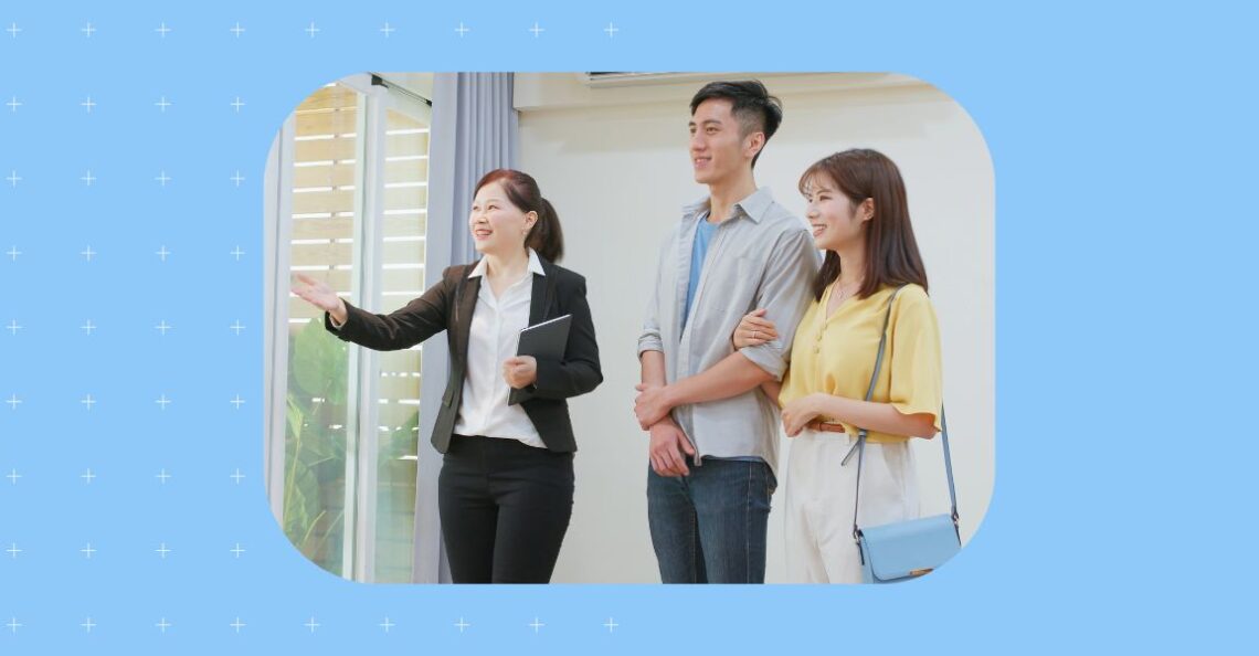 Image shows a real estate agent showing a house around to potential homeowners